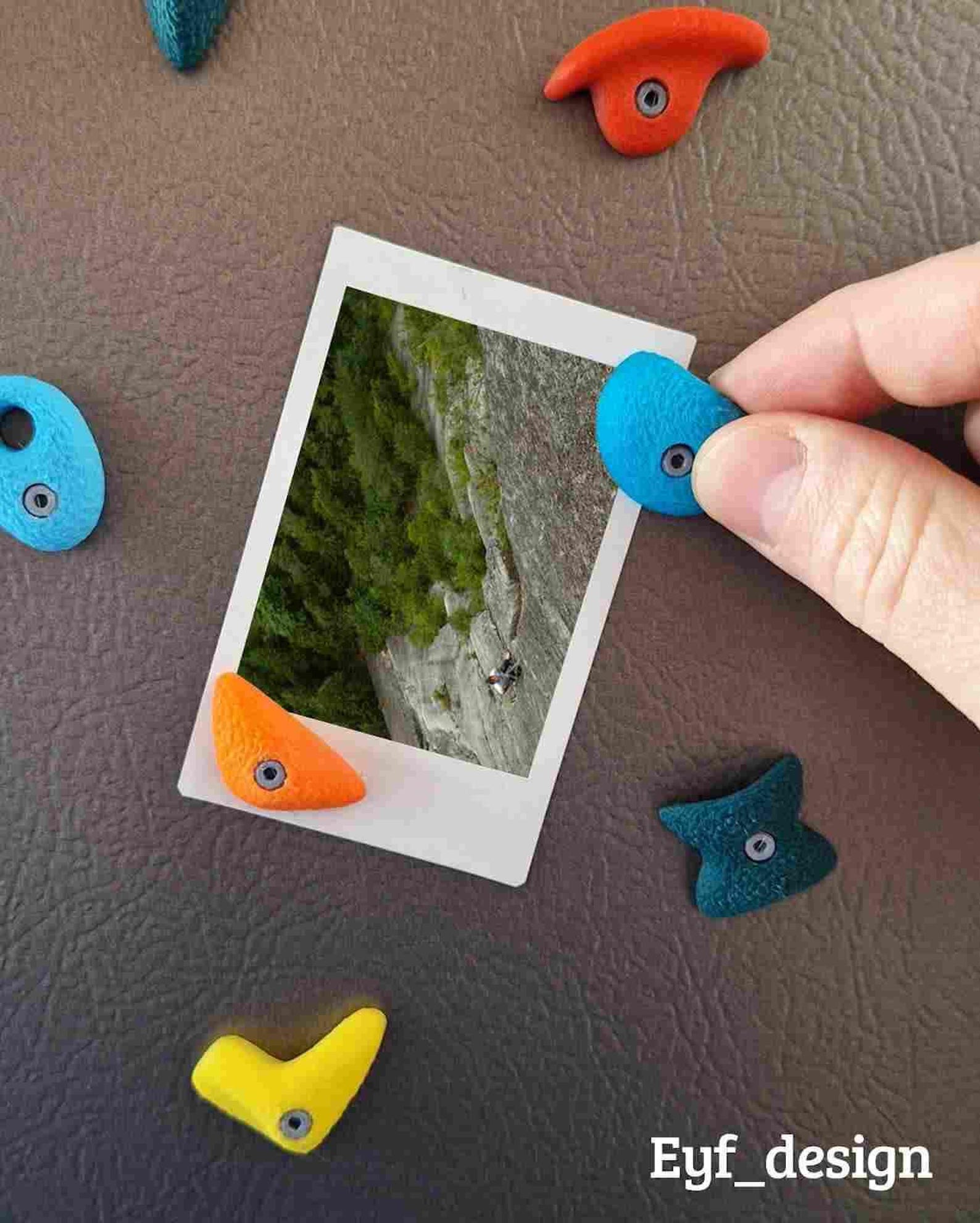 3D printed climbing hold magnets on a refrigerator door