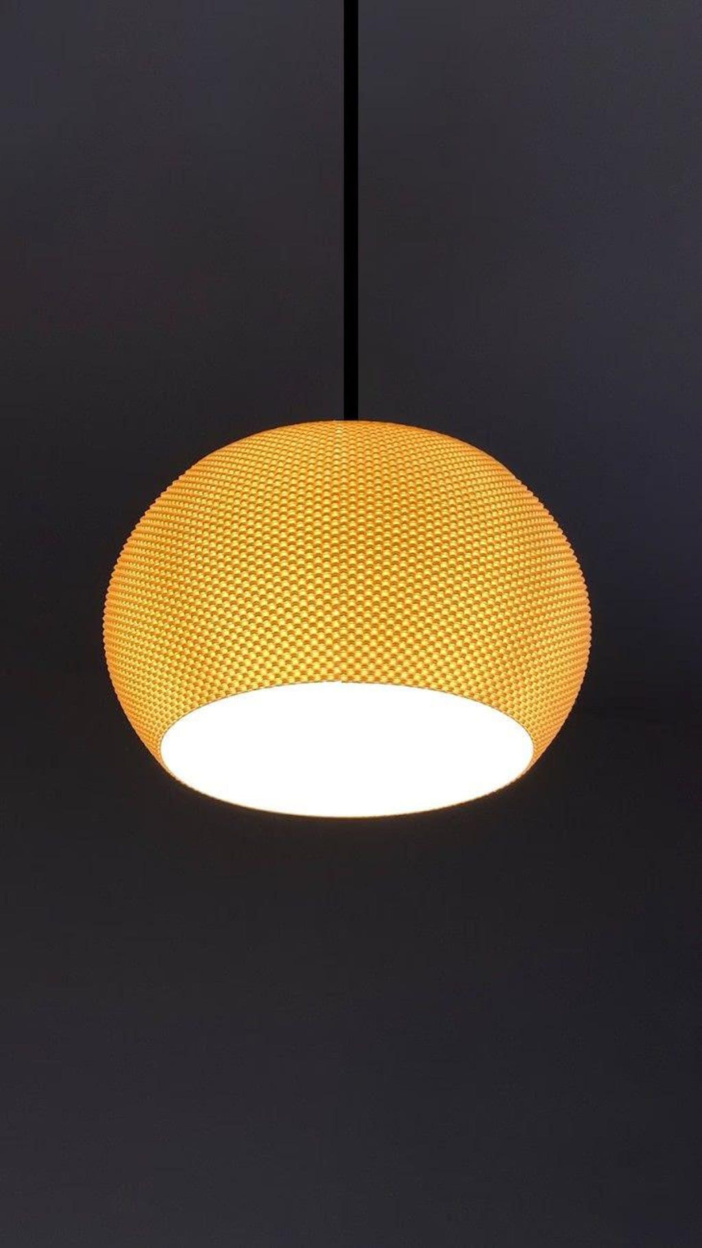 Valo 3D printed sculptural table lamp shade glowing warm on a bedside table