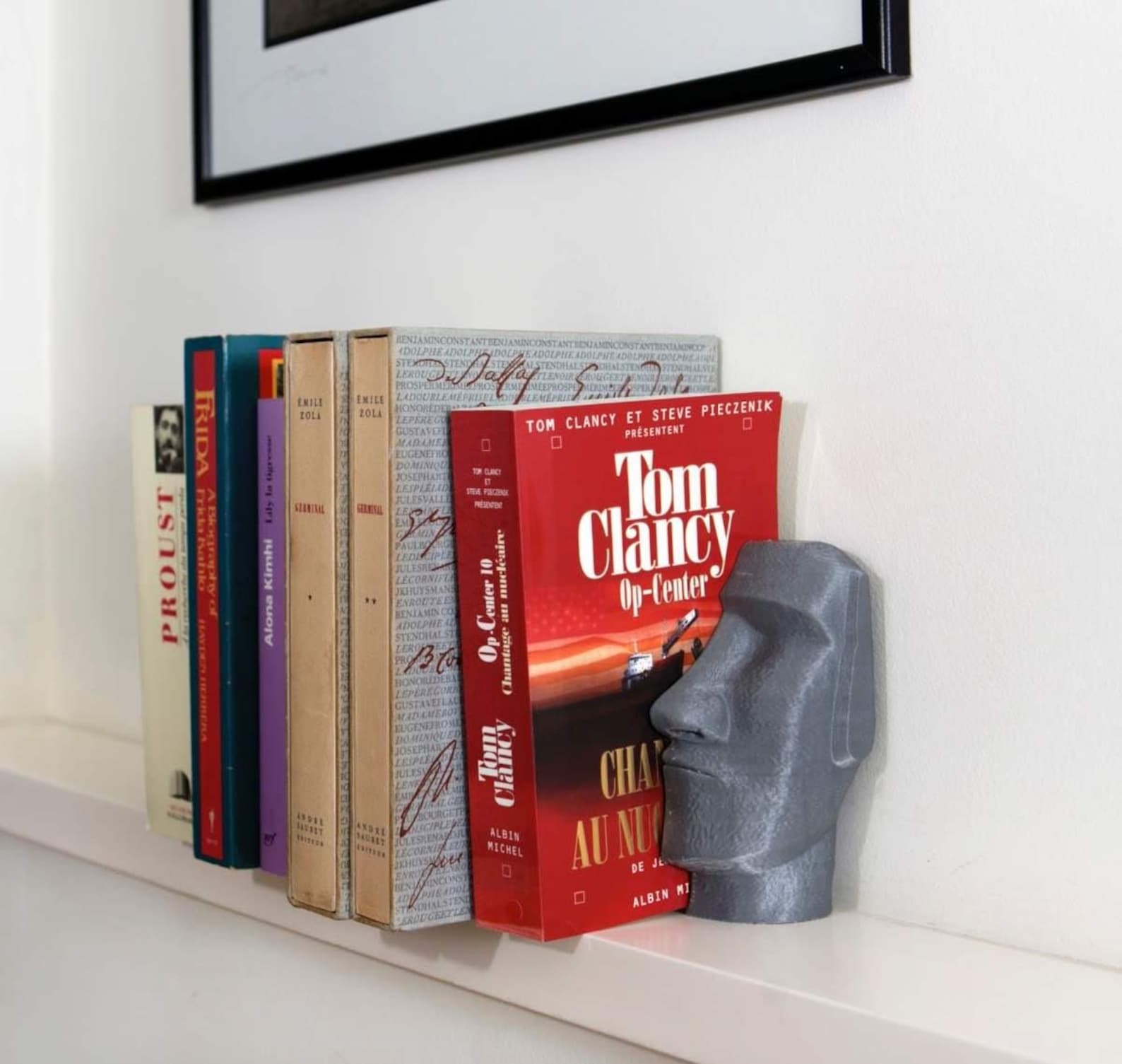 Moai head 3D printed bookend holding books on a shelf