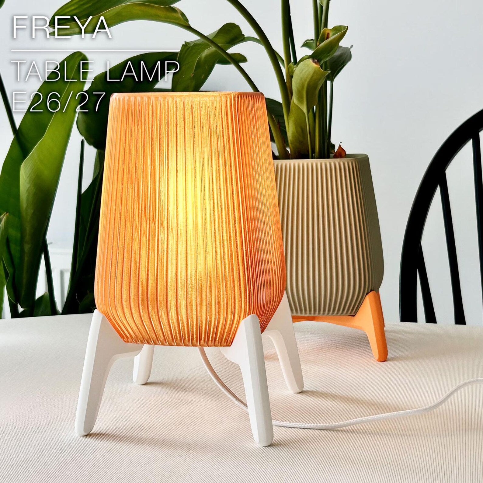 Modern 3D printed table lamp with printed shade glowing on a bedside table