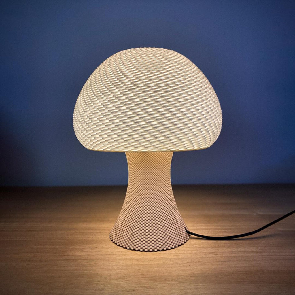 Mushroom table lamp with rippled shade glowing warmly on a nightstand
