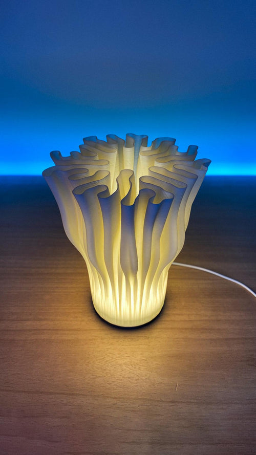 Coral table lamp glowing with dappled light
