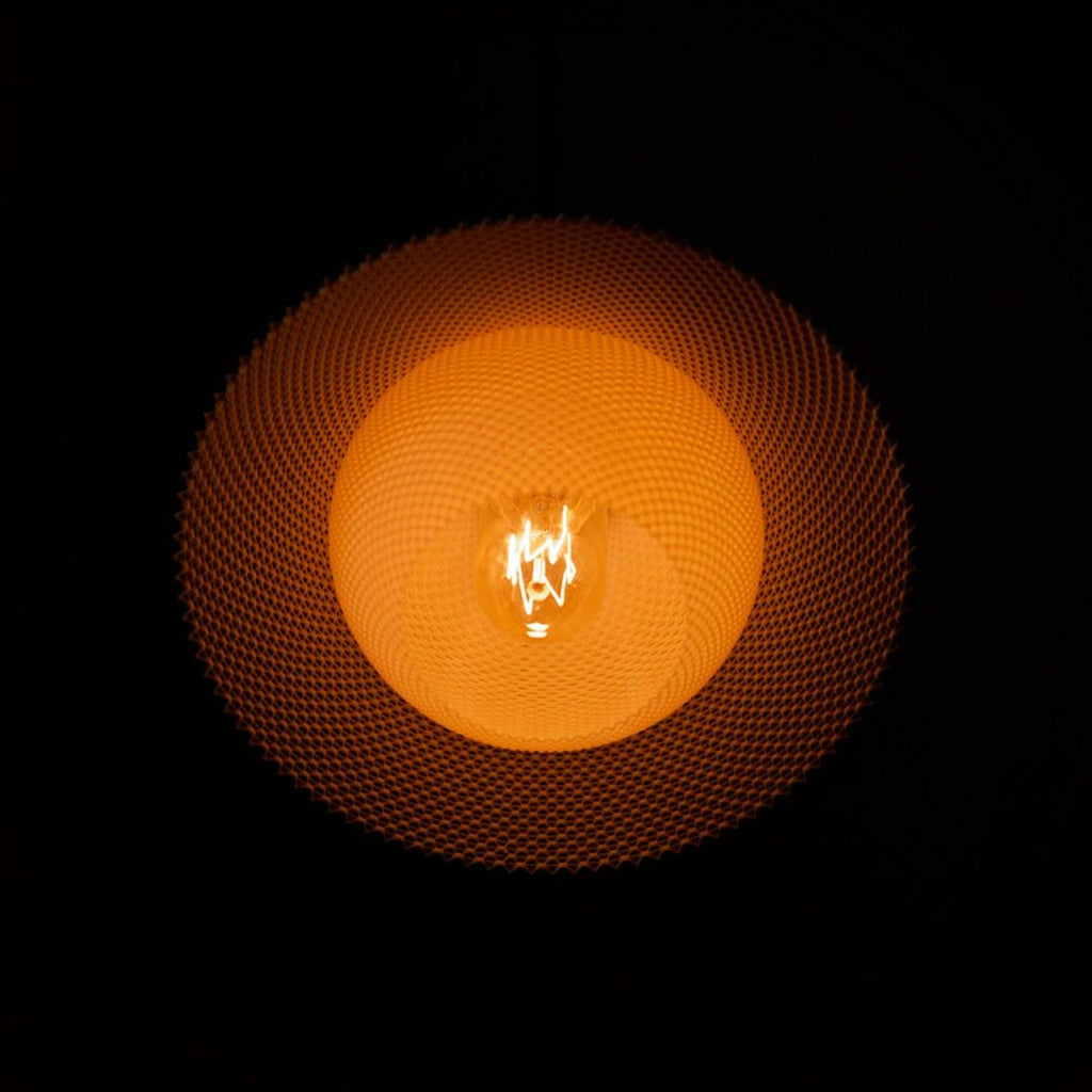 Orson saucer pendant glowing over a table