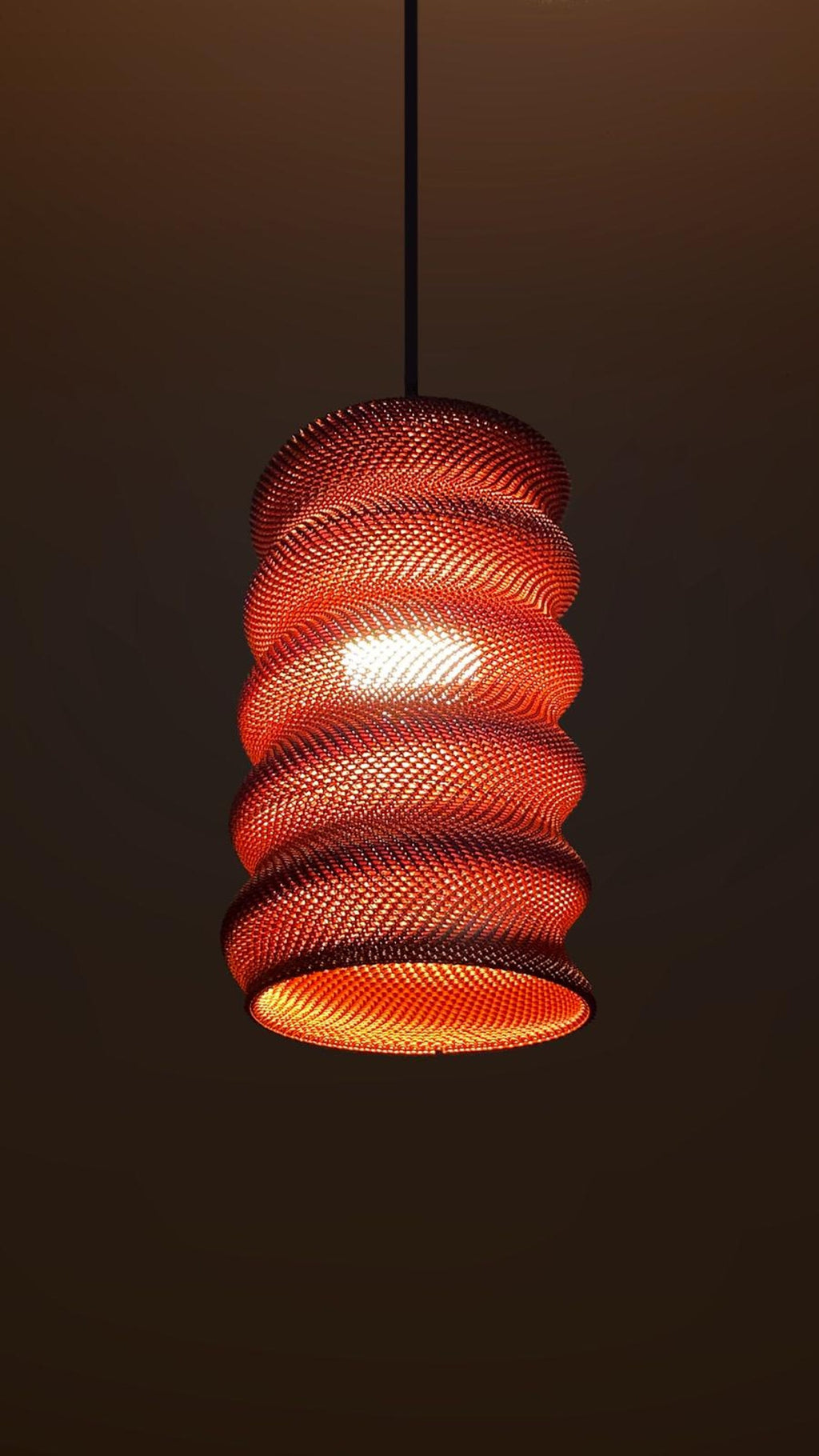 Detail of the warm woven glow of the spiral shade