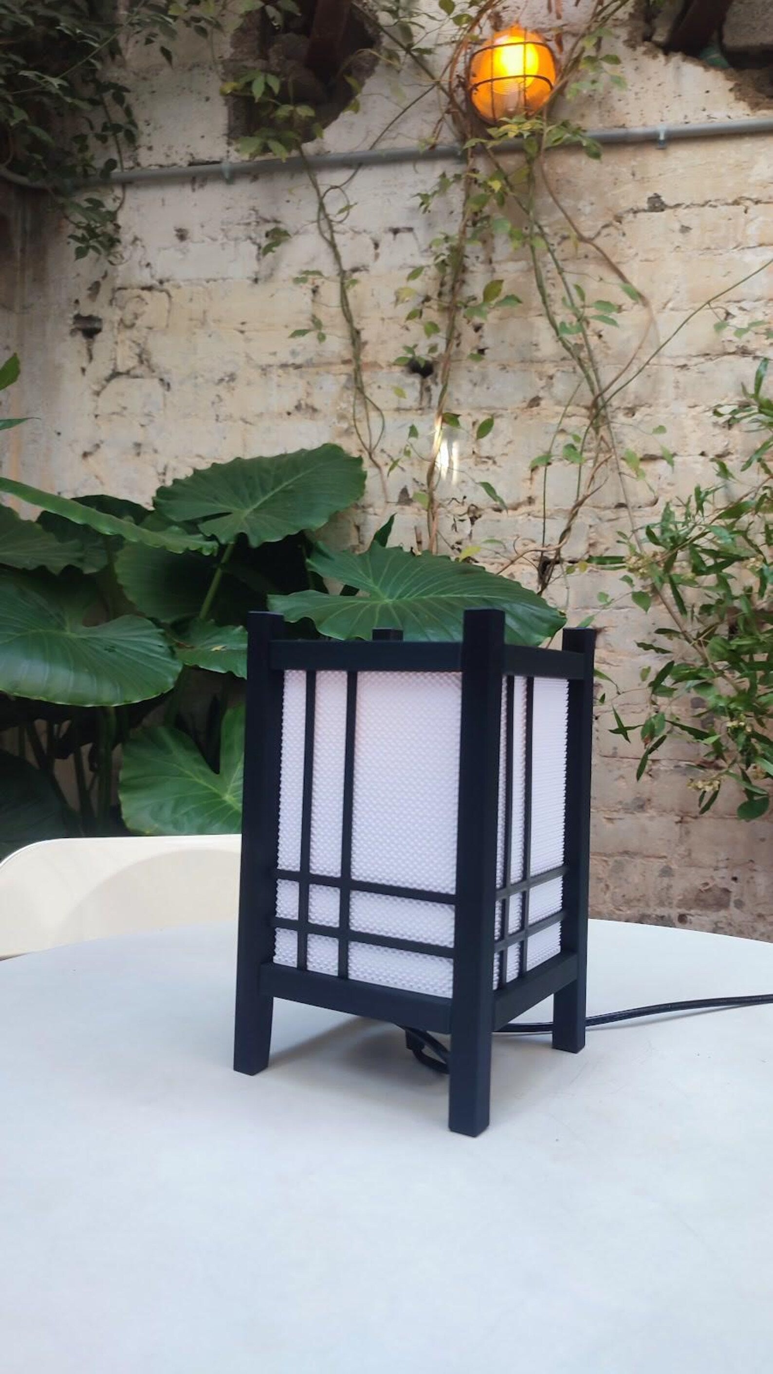 Shoji table lamp glowing on a nightstand
