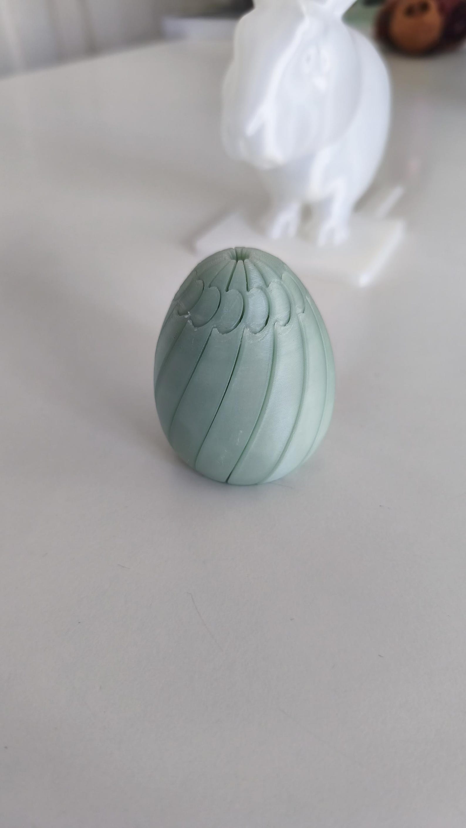 3D printed Easter egg fidget clicker with spiral ridges in mint green