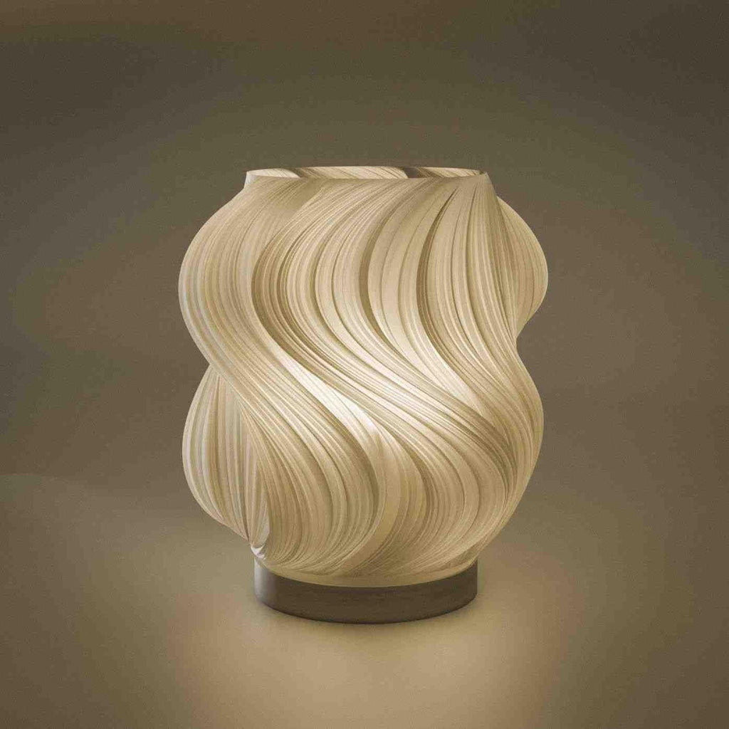 Modern wave table lamp with swirling textured shade on a dark base