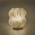 Modern wave table lamp with swirling textured shade on a dark base
